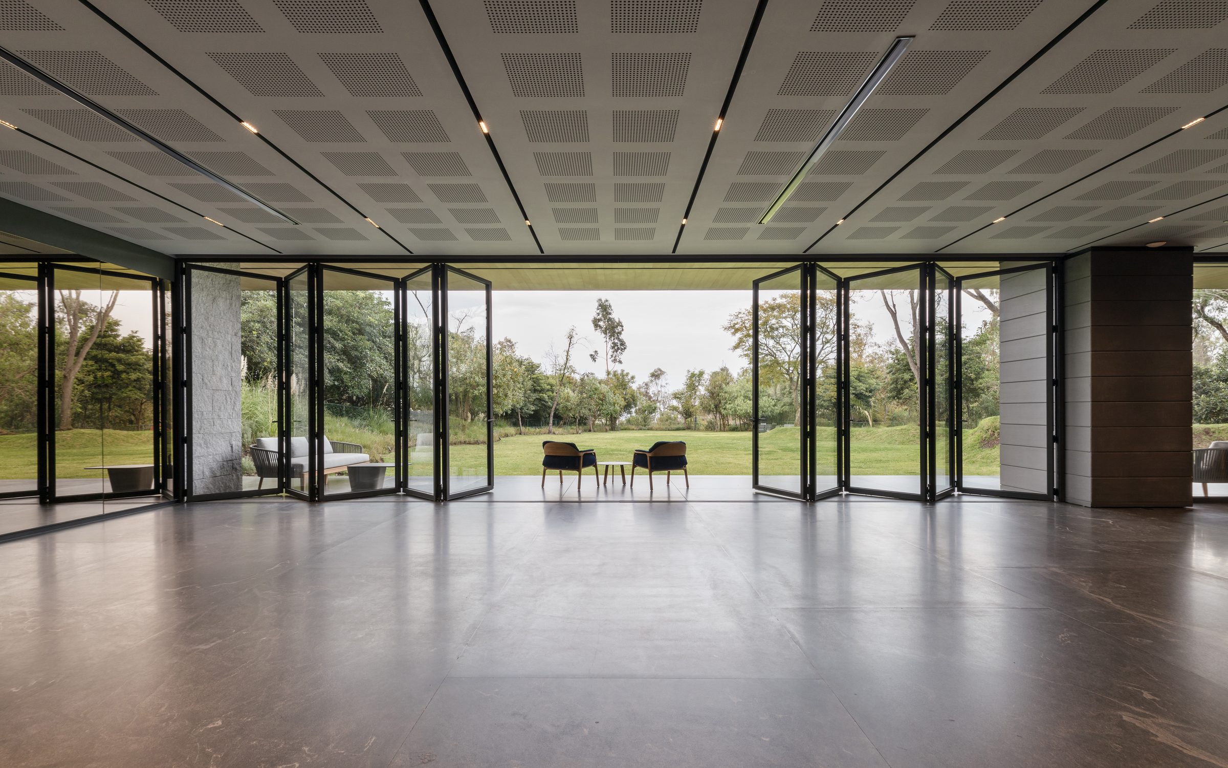 Panoramic Fold 80 aluminium bifold doors folded fully open along a wide garden room