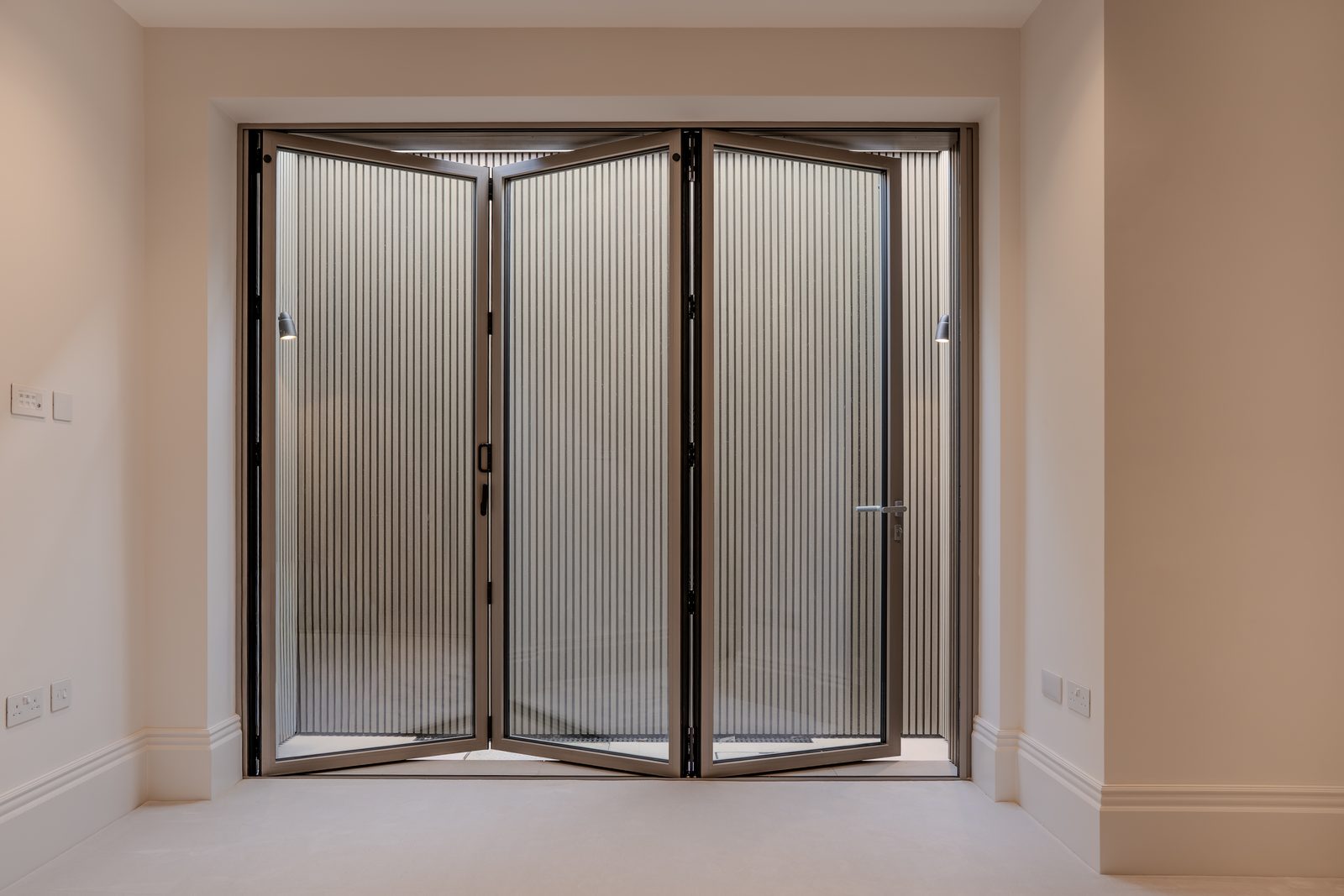 Three-panel bifold door closed, bronze finish, seen from inside