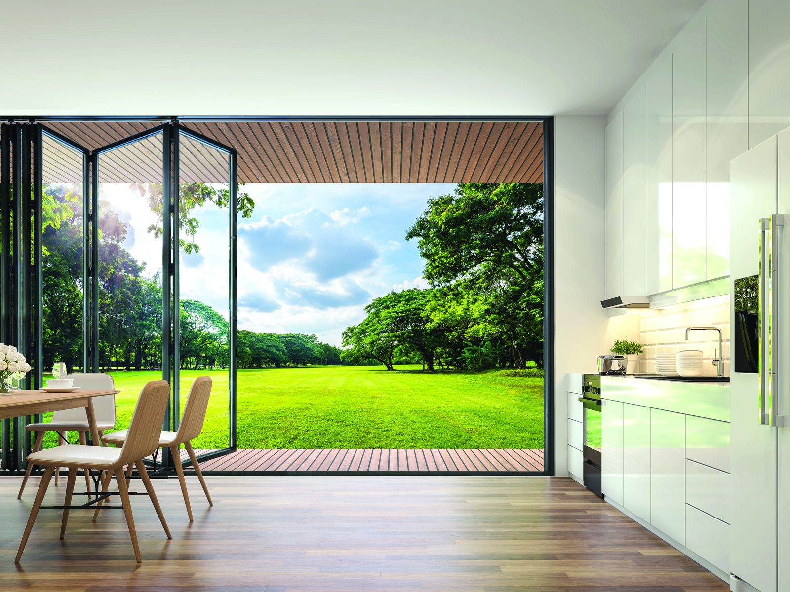Kitchen with dark aluminium bifold doors folded open onto a garden